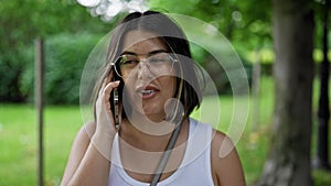 Young beautiful hispanic woman smiling happy speaking on the phone at the park in Vienna