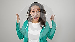 Young beautiful hispanic woman standing with surprise expression over isolated white background