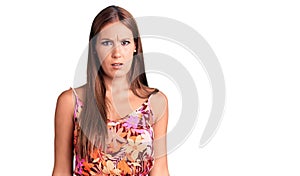 Young beautiful hispanic woman wearing casual clothes in shock face, looking skeptical and sarcastic, surprised with open mouth