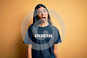 Young beautiful hispanic woman wearing volunteer t-shirt as social charity moral In shock face, looking skeptical and sarcastic,