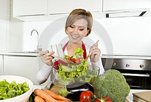 Young beautiful home cook woman at modern kitchen preparing vegetable salad bowl smiling happy