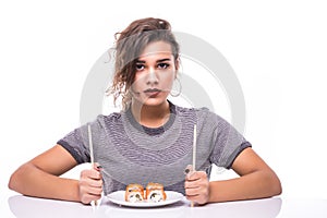 Young beautiful hungry woman holding sushi with chopsticks isolated on white background