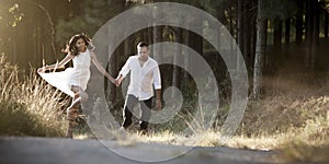 Young beautiful Indian couple dancing playfully in field