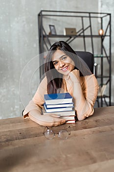 Young, beautiful Indian student sitting at the table