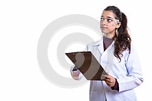 Young beautiful Indian woman doctor holding clipboard while thin