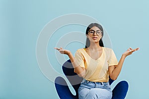 Young beautiful indian woman in glasses with closed eyes meditating