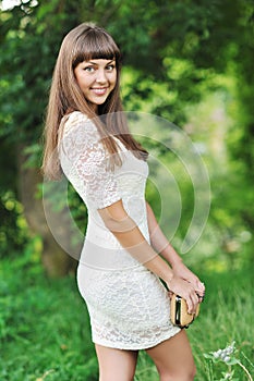 Young beautiful lady in a green park in summer