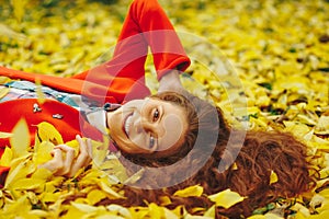 Young beautiful lady surrounded autumn leaves