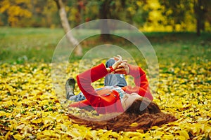 Young beautiful lady surrounded autumn leaves