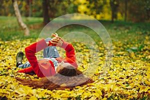 Young beautiful lady surrounded autumn leaves