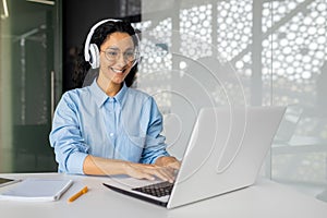 Young beautiful latin american programmer working inside office with laptop, woman coding new software security smiling