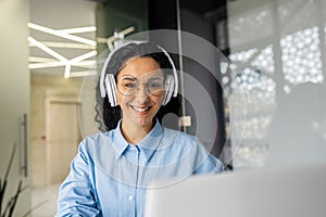 Young beautiful latin american programmer working inside office with laptop, woman coding new software security smiling