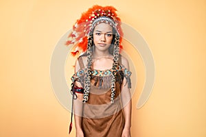 Young beautiful latin girl wearing indian costume relaxed with serious expression on face