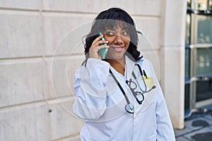 Young beautiful latin woman doctor smiling confident talking on smartphone at hospital