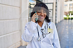 Young beautiful latin woman doctor smiling confident talking on smartphone at hospital