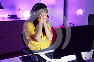Young beautiful latin woman streamer stressed using computer at gaming room