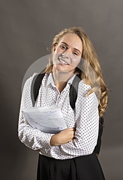 Young beautiful longhaired student girl with papers looks happy