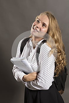 Young beautiful longhaired student girl with papers looks happy