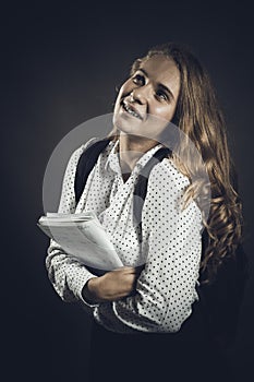 Young beautiful longhaired student girl with papers looks happy