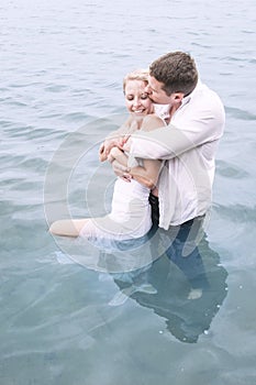 Young beautiful lovers in pool of water sharing an intimate moment