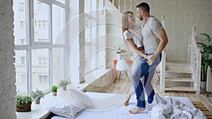 Young beautiful and loving couple dancing rocknroll dance on bed in the morning at home photo