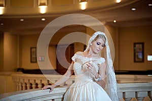 Young beautiful luxurious woman in wedding dress posing in luxurious interior. Bride with huge wedding dress in majestic manor