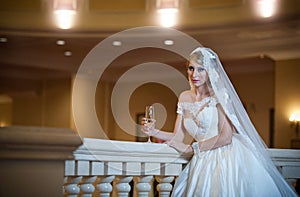 Young beautiful luxurious woman in wedding dress posing in luxurious interior. Bride with huge wedding dress in majestic manor