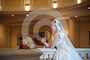 Young beautiful luxurious woman in wedding dress posing in luxurious interior. Bride with huge wedding dress in majestic manor