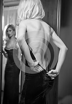 Young beautiful luxurious woman zipping up her dress photo