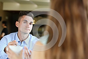 Young beautiful man and woman meet in cafe business