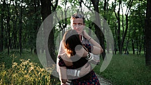 Young beautiful married couple man and woman fool around, hug and laugh in Park in summer. Happy people, concept of relationships