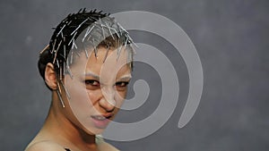 Young beautiful model with unusual hairstyle posing for a photo in studio