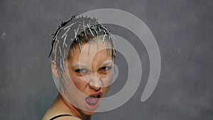 Young beautiful model with unusual hairstyle posing for a photo in studio