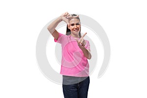 young beautiful model woman with straight black hair dressed in a pink t-shirt shows a frame with her hands