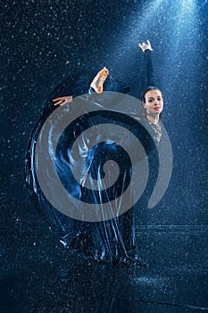 The young beautiful modern dancer dancing under water drops