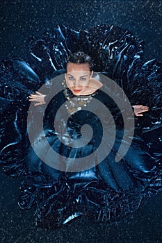 The young beautiful modern dancer dancing under water drops