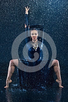 The young beautiful modern dancer dancing under water drops