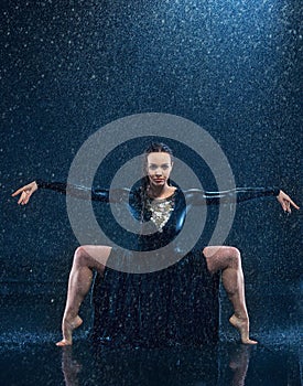 The young beautiful modern dancer dancing under water drops