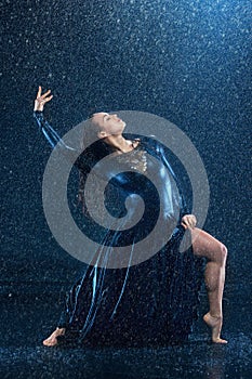 The young beautiful modern dancer dancing under water drops