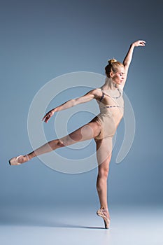 Young beautiful modern style dancer posing on a studio background