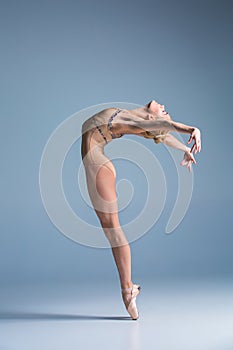 Young beautiful modern style dancer posing on a studio background