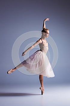 Young beautiful modern style dancer posing on a studio background