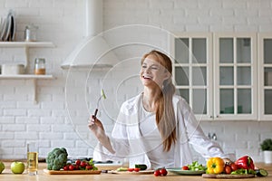 Young beautiful modern woman stands near table on kitchen at home