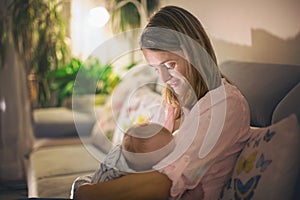 Young beautiful mother, breastfeeding her newborn baby boy