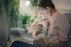 Young beautiful mother, breastfeeding her newborn baby boy