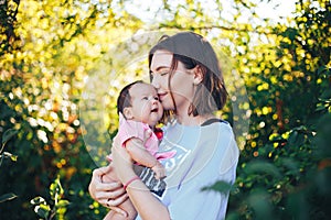 young beautiful mother with dark hair hold her newborn baby girl