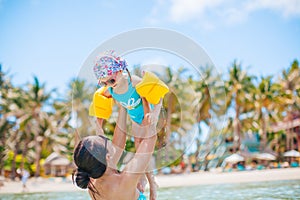 Young beautiful mother having fun with her daughter on tropical beach vacation