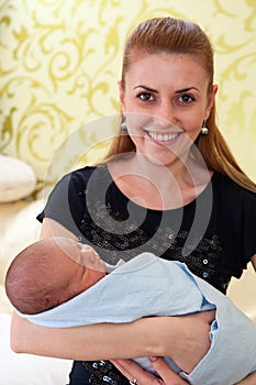 Young beautiful mother holding newborn baby boy