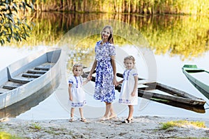 young beautiful mother spending time together with children in boat on lake at park. mothers day. womens day.