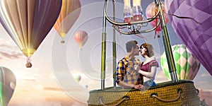 Young beautiful multiethnic couple kissing in the hot air balloon.